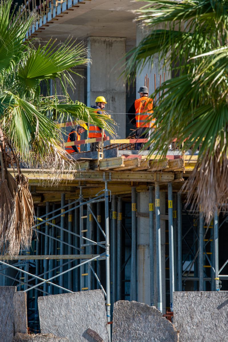 Construction crew on a building site with palm trees in the Phoenix area