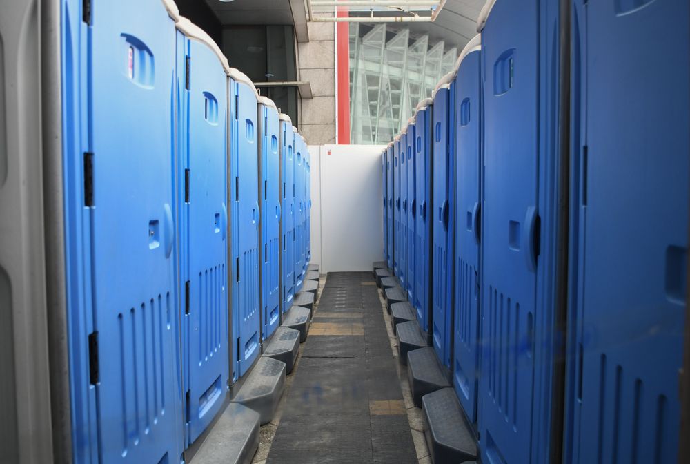 Row of clean blue portable toilets set up for a large event